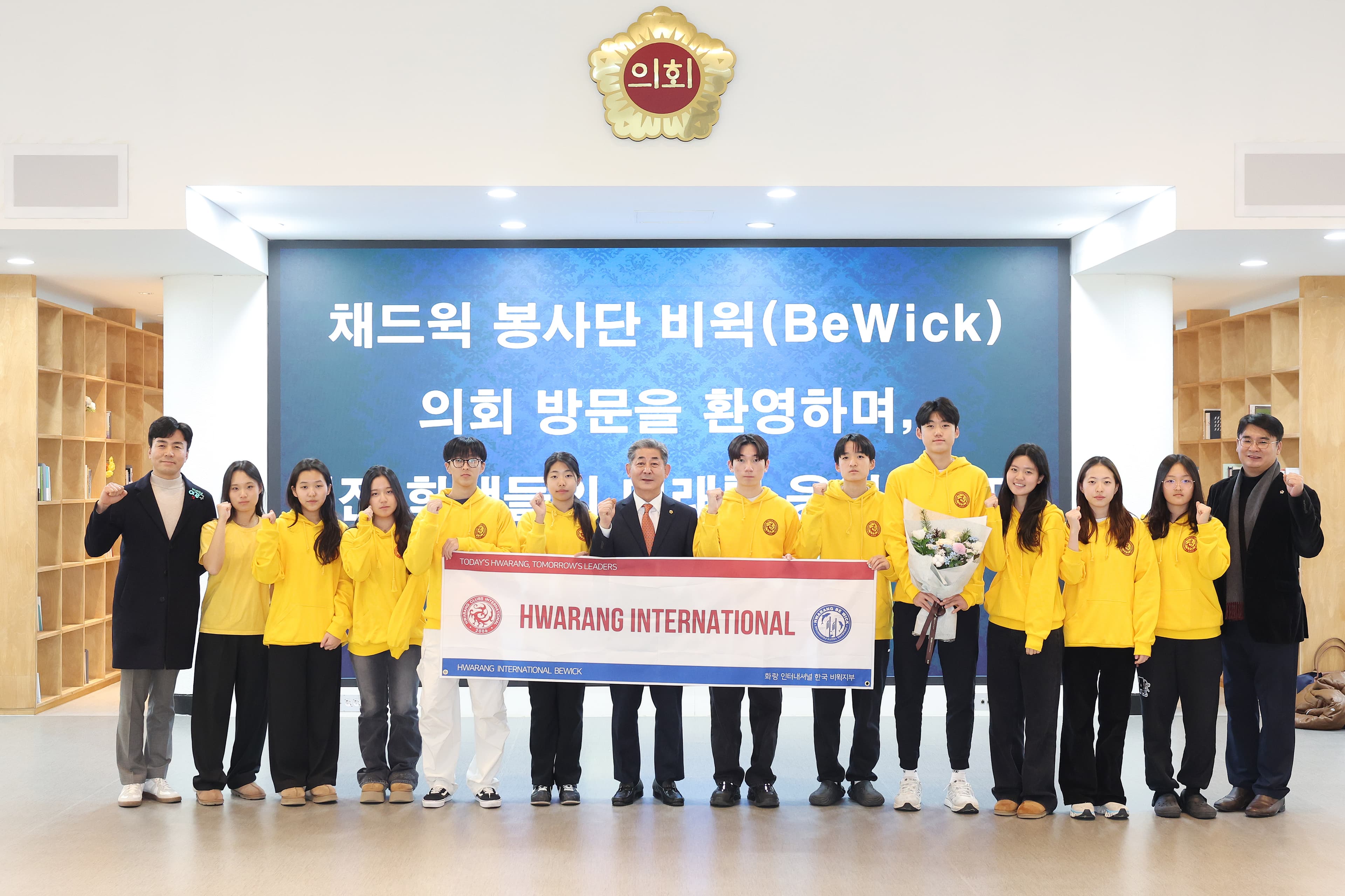 Large group photo of team members standing together with an event banner